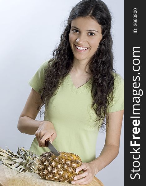 Smiling girl is cutting pineapple. Smiling girl is cutting pineapple