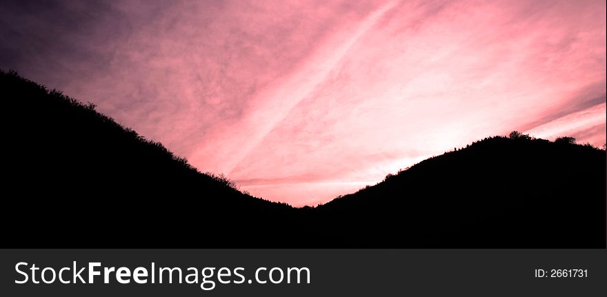 Night scape of mountains whit strong cloudy red sky