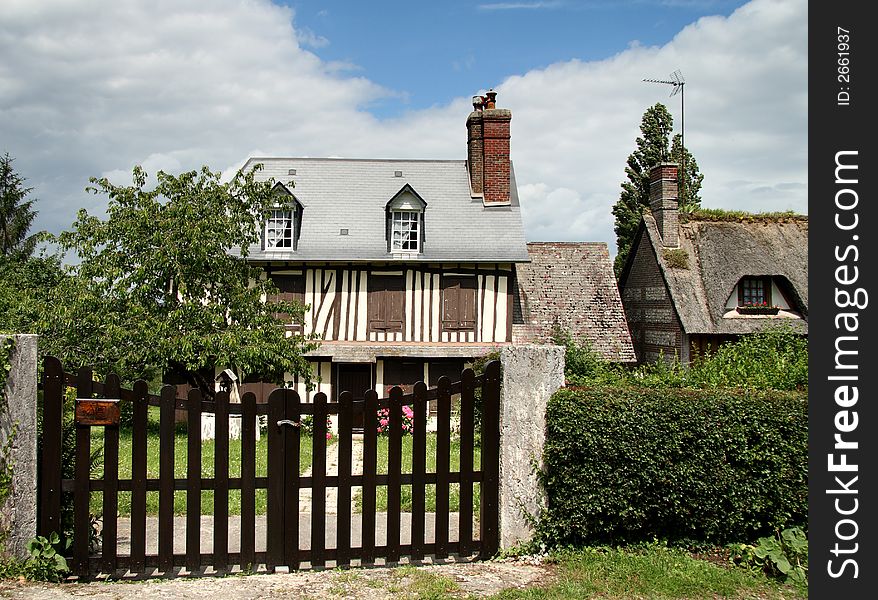 Timber Framed Village House in Normandy, with shuttered windows and picket gate to the front. Timber Framed Village House in Normandy, with shuttered windows and picket gate to the front