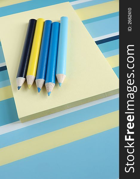 Notepads and pencils in blue and yellow. Notepads and pencils in blue and yellow