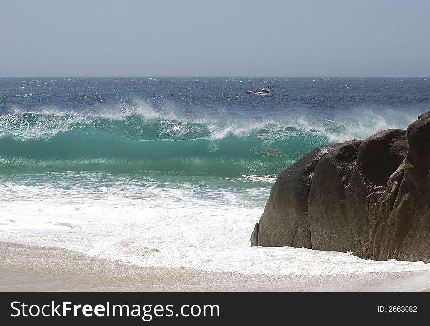 Monstrous green wave is hitting Lovers' beach in Cabo San Lucas.