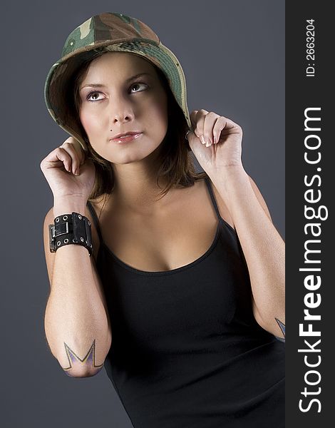 Attractive brunette military girl with a camouflage hat and black shirt. Attractive brunette military girl with a camouflage hat and black shirt