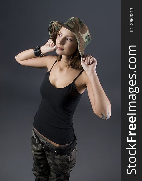 Attractive brunette military girl with a camouflage hat and black shirt. Attractive brunette military girl with a camouflage hat and black shirt