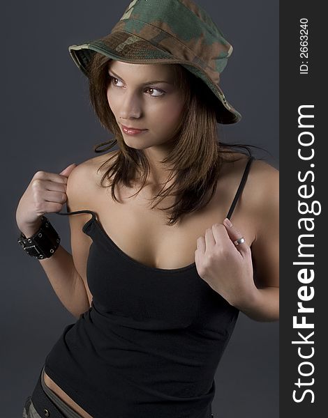 Attractive brunette military girl with a camouflage hat and black shirt. Attractive brunette military girl with a camouflage hat and black shirt