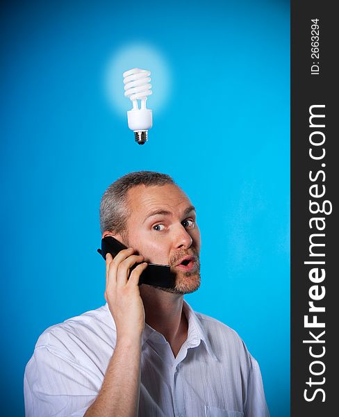 Man with a beard with a light bulb on the phone. Man with a beard with a light bulb on the phone