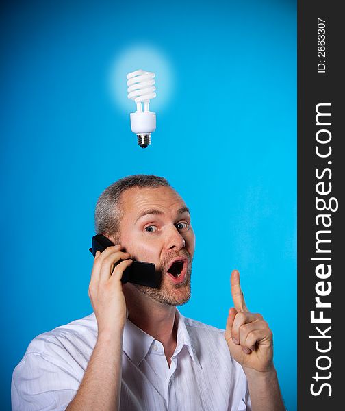 Man wih a beard with a light bulb on the phone. Man wih a beard with a light bulb on the phone