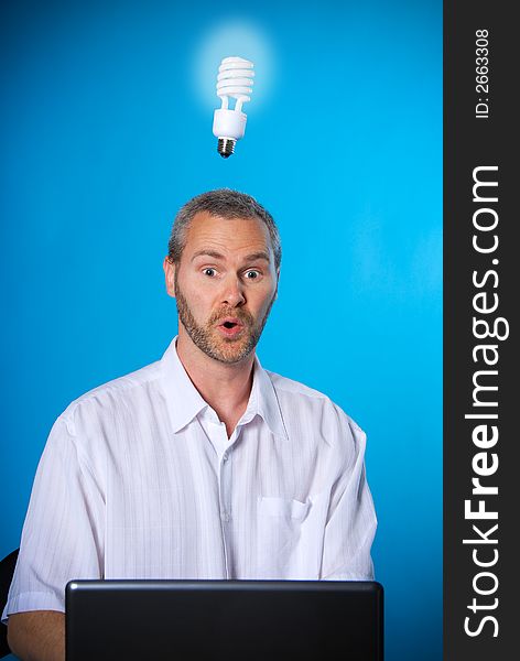 Man with a beard with a light bulb on the laptop. Man with a beard with a light bulb on the laptop