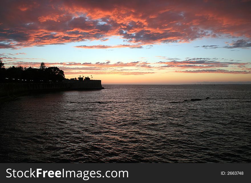 Sunset over the sea with old castle and clouds. Sunset over the sea with old castle and clouds