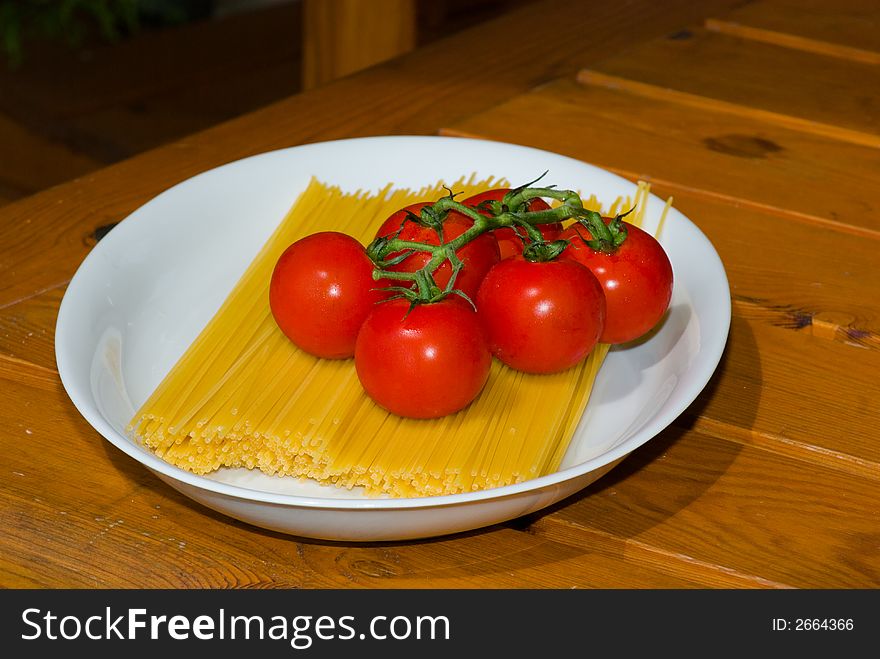 plate  spaghetti and tomato,foodstuff ready for boiling. plate  spaghetti and tomato,foodstuff ready for boiling