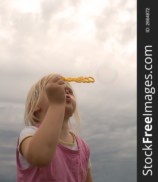 Young girl blowing soap bubbles. Young girl blowing soap bubbles