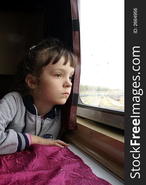 The girl looks in a window of a compartment. The girl looks in a window of a compartment