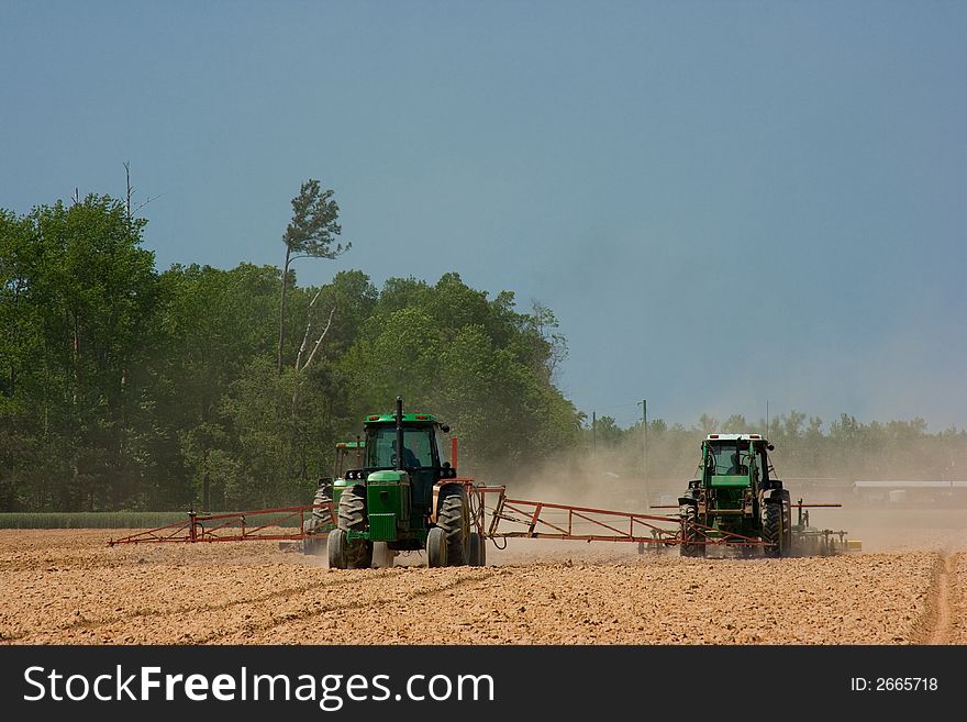 Farmers plowing a dusty field in rural America for the next year's harvest. Farmers plowing a dusty field in rural America for the next year's harvest