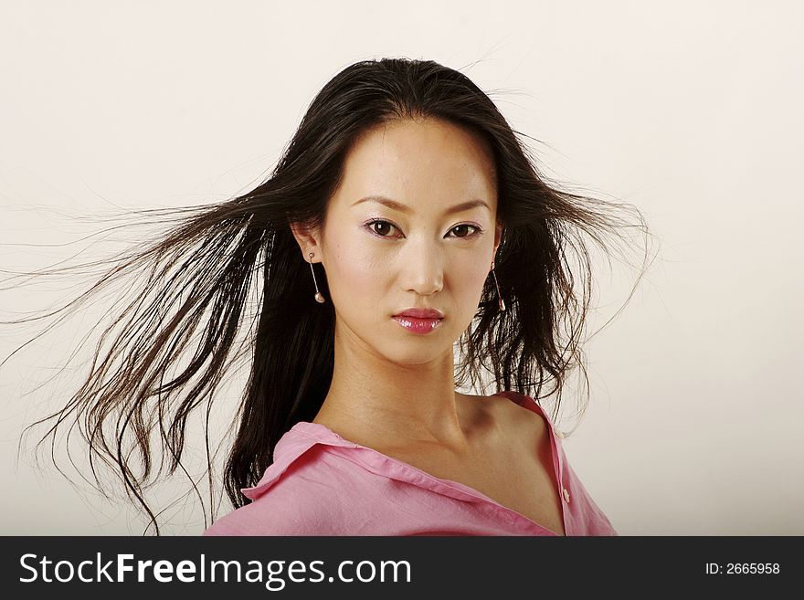 Enticing Chinese girl with flying hair in pink shirt