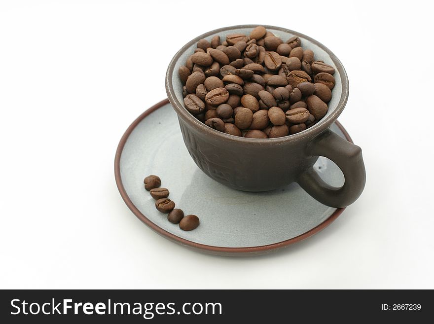 Cup of coffee beans on white