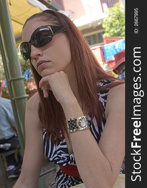 Beautiful young woman looking bored in a sidewalk cafe in Sorrento, Italy.