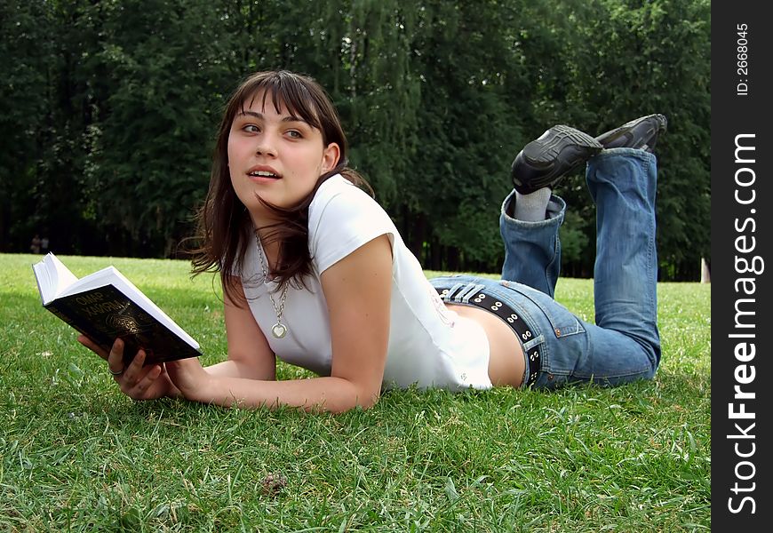 Girl with the book lays on a grass. Girl with the book lays on a grass