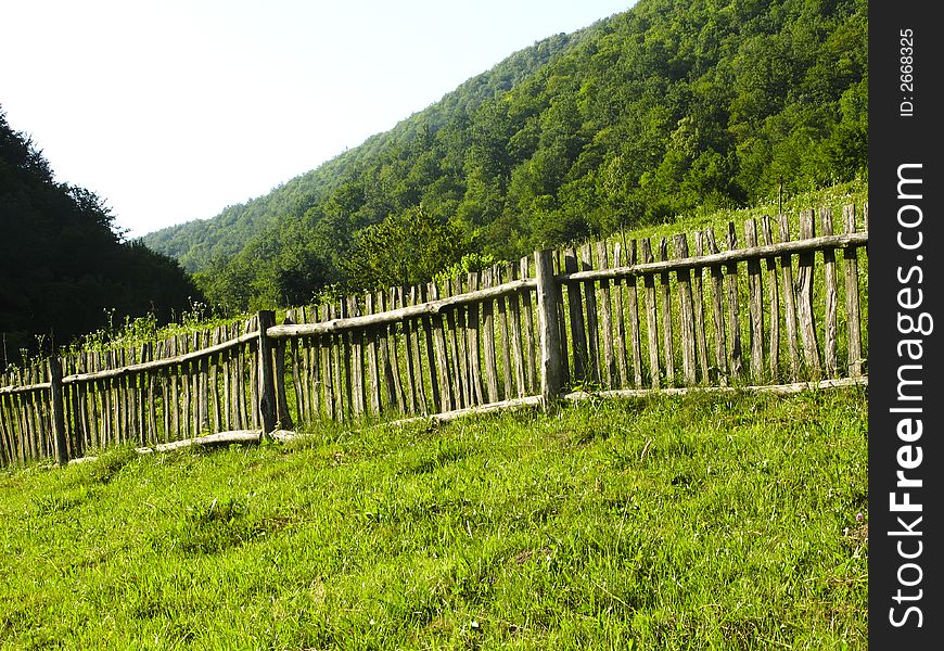 Old classic nice wooden fence in the summer meadow