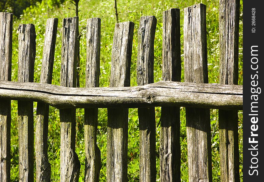 Old classic nice wooden fence in the summer meadow