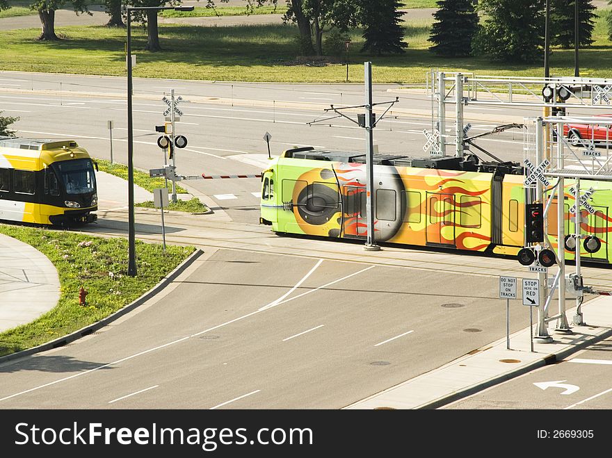 Light rail mass transit trains cross at an intersection in Bloomington, MN. Light rail mass transit trains cross at an intersection in Bloomington, MN