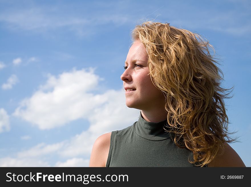 Young girl profile portrait in cloudy background