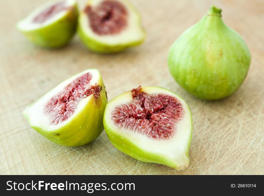 Fresh figs cut in half on wooden board