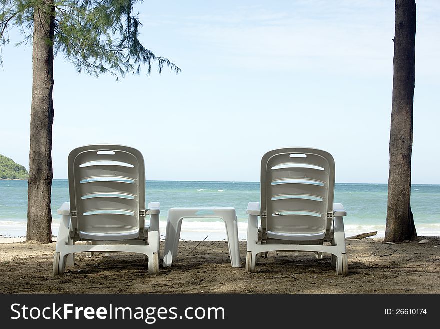 Two beach chairs and 2 parasols on the beach. Two beach chairs and 2 parasols on the beach