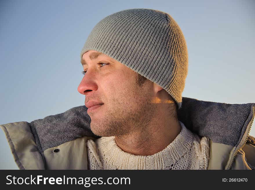 Portrait of man in warm gray jacket and hat. Half-face. Portrait of man in warm gray jacket and hat. Half-face.