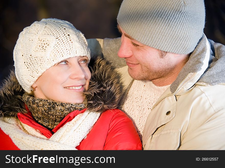 Portrait of women embracing her boyfriend in the winter park. Portrait of women embracing her boyfriend in the winter park.