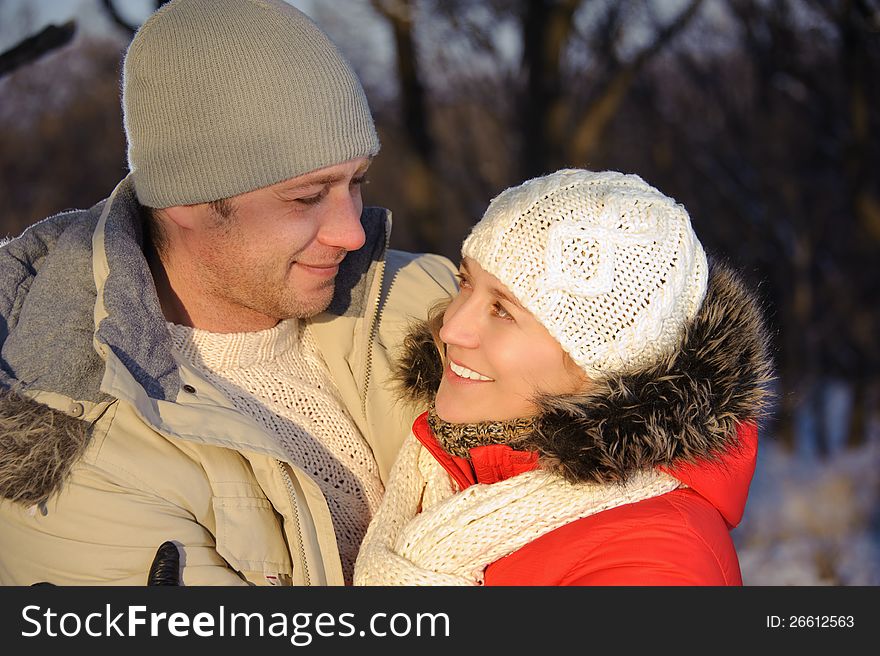 Portrait of women embracing her boyfriend in the winter park. Portrait of women embracing her boyfriend in the winter park.