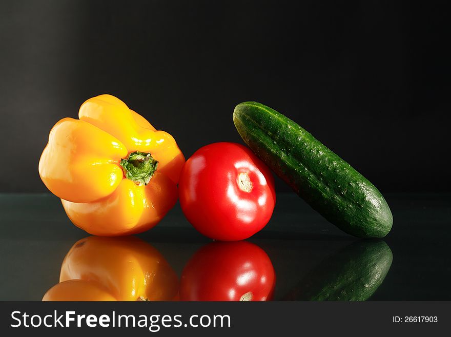 Color vegetables on dark background with reflection