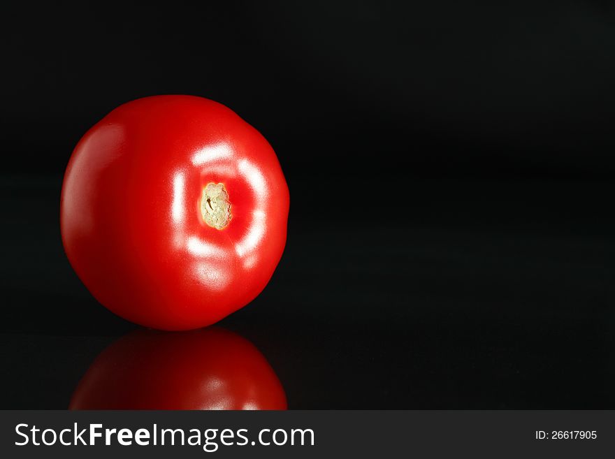 Ordinary freshness red tomato on black background with reflection