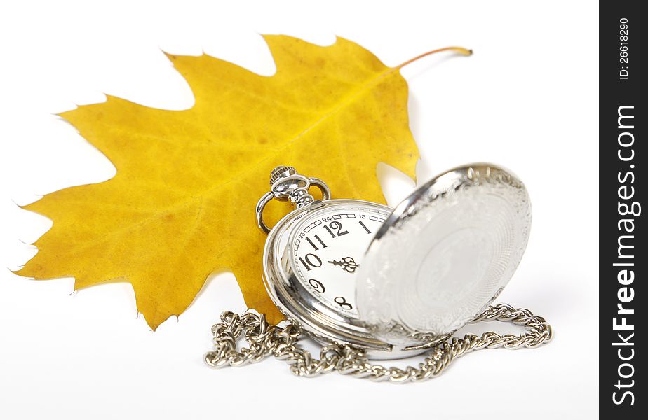 Yellow oak leaf and pocket watch on the white background. Yellow oak leaf and pocket watch on the white background