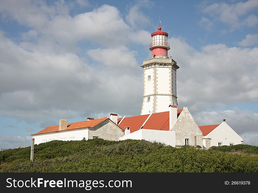 Old lighthouse on the background of blue sky with clouds. Old lighthouse on the background of blue sky with clouds