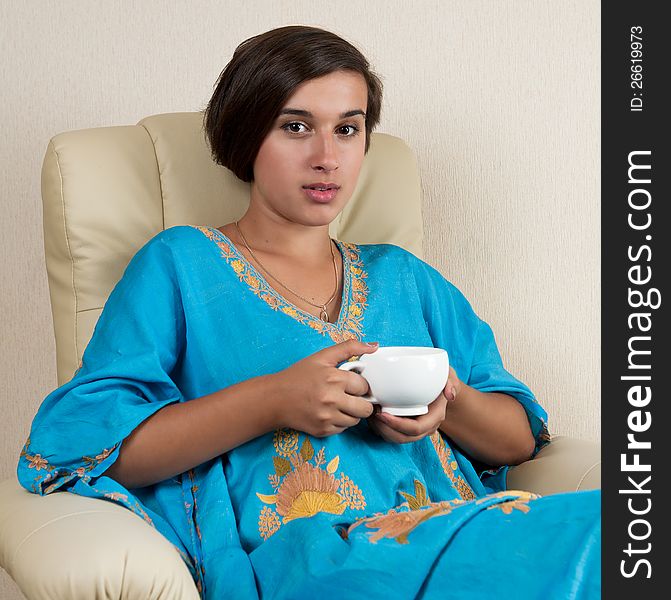 Girl Sitting In Chair With Cup