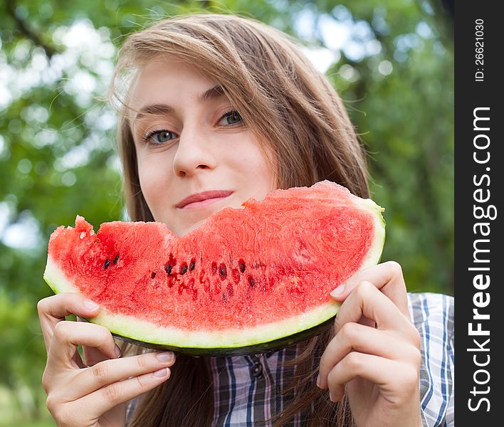 Young woman with watermelon outdoors. Focus on watermelon. Young woman with watermelon outdoors. Focus on watermelon