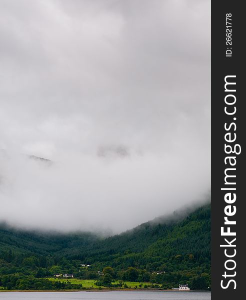 Landscape for scotland at glencoe area, Fort williams, Scottish Highlands. Mountain hidden in fog with cottage house at the base. Landscape for scotland at glencoe area, Fort williams, Scottish Highlands. Mountain hidden in fog with cottage house at the base.