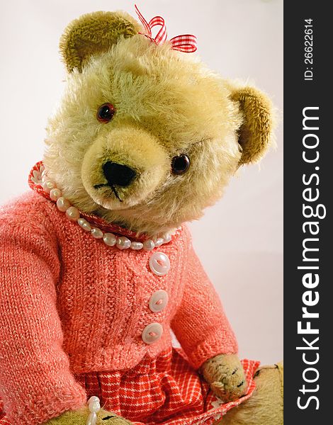 An old teddy bear toy from the 60s with sawdust stuffing and homemade clothes. An old teddy bear toy from the 60s with sawdust stuffing and homemade clothes