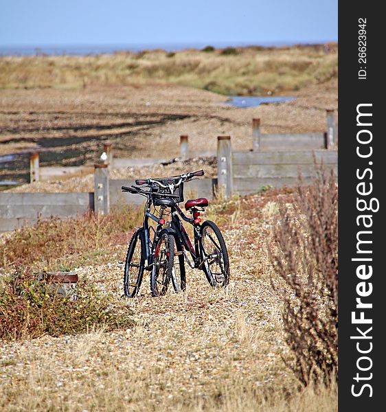 Photo of two bicycles standing alone on a beach in whitstable. Photo of two bicycles standing alone on a beach in whitstable.