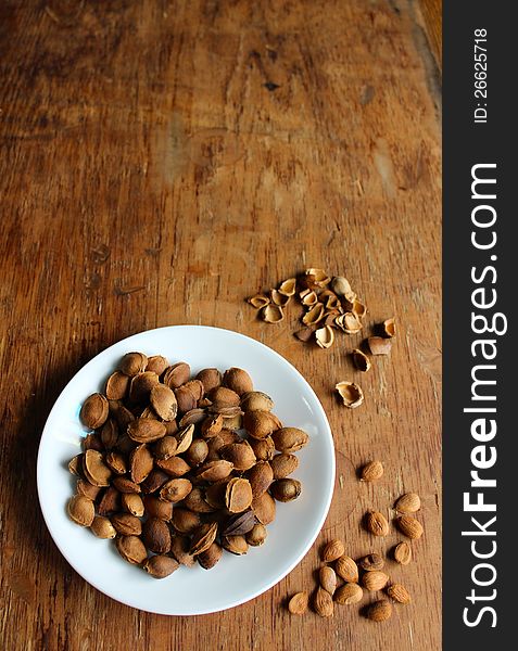 Pile of apricot seeds on a white plate. Pile of apricot seeds on a white plate