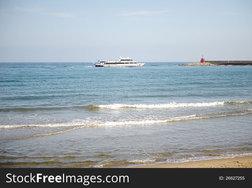 Italian landscape, the ship sailing on the sea and red lighthouse