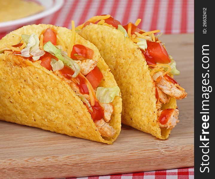 Two chicken tacos with tomato, lettuce, cheese and sauce. Two chicken tacos with tomato, lettuce, cheese and sauce
