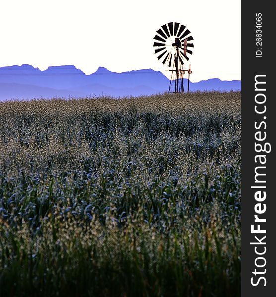 Landscape with windmill water pump at sunrise with ceres mountains