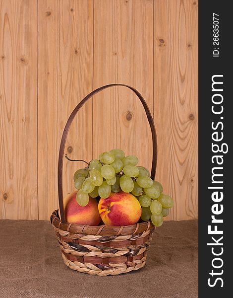 Ripe grapes, peach, apple in the basket. Ripe grapes, peach, apple in the basket