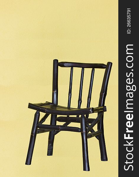 A traditional chair with yellow background and shadow