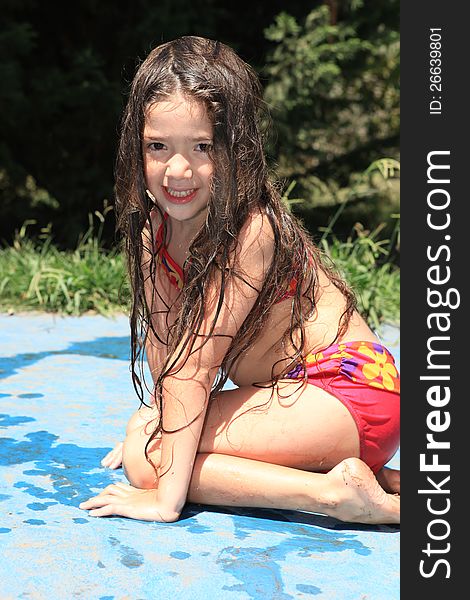 Smiling little girl sitting by the pool. Smiling little girl sitting by the pool