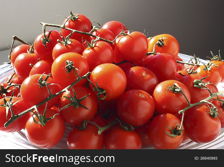 Vine grown tomatoes in a glass bowl. Vine grown tomatoes in a glass bowl