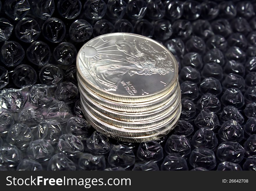 Stack of silver dollars protected by bubble wrap. Stack of silver dollars protected by bubble wrap