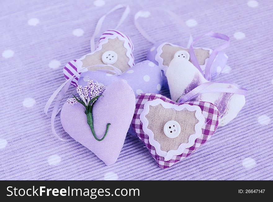 Decorative lavender aroma hearts placed on table napkin of tender lavender color. Decorative lavender aroma hearts placed on table napkin of tender lavender color