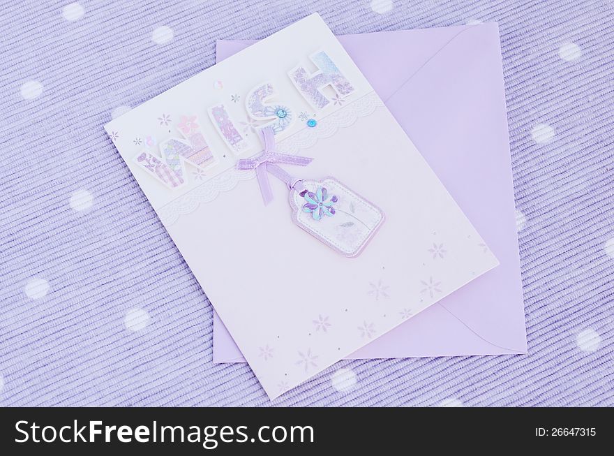 Tender postcard with word Wish placed on table napkin of lavender color. Tender postcard with word Wish placed on table napkin of lavender color