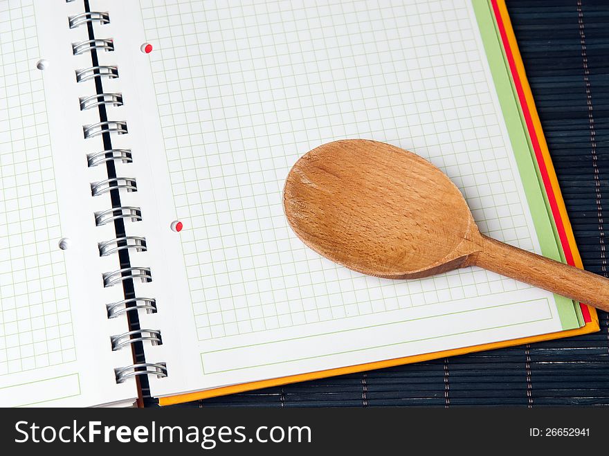 Wooden Spoon on a blank spiral notebook. Wooden Spoon on a blank spiral notebook.
